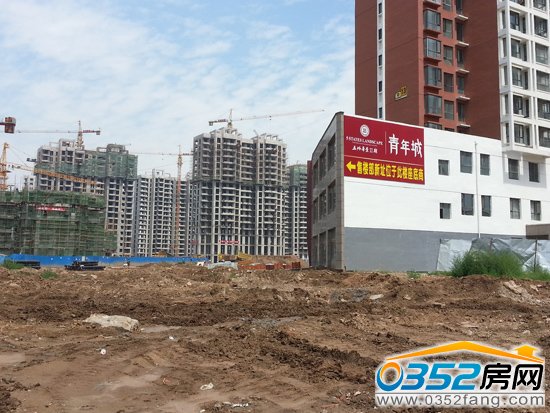 青年城接待中心的標語與周邊泥濘的道路形成鮮明對比