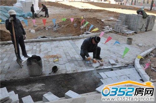 3號樓單元門前建筑工人鋪設地磚